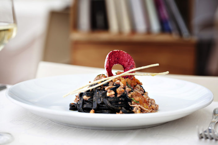 Elegante fotografia di linguine al nero di seppie. Fotografo per ristoranti food piatti gourmet