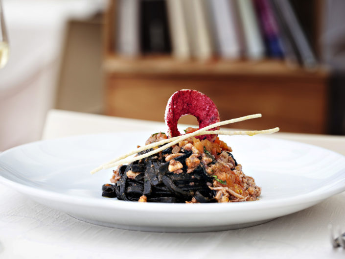 Elegante fotografia di linguine al nero di seppie. Fotografo per ristoranti food piatti gourmet