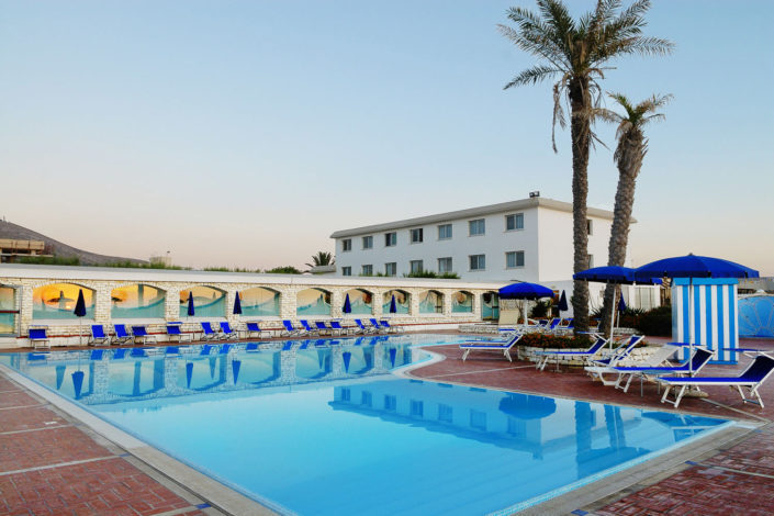 Grande piscina con due palme ed i lettini di un albergo a Trapani fotografia di nino lombardo fotografo