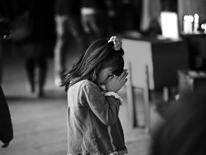 Foto Reportage in bianco e nero realizzate in Giappone, Usi e costumi di un popolo, qui in foto una bambina china in preghiera